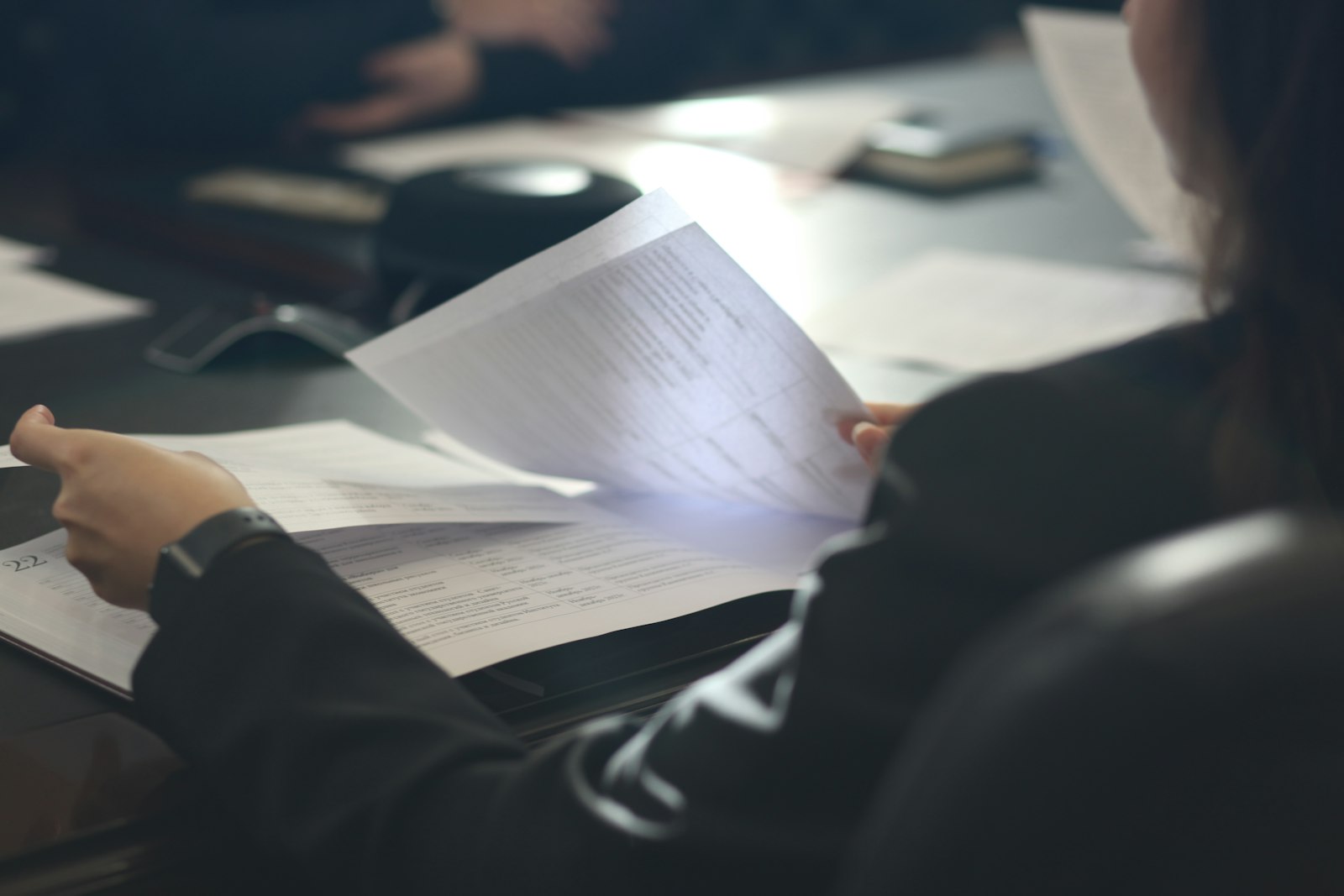 Person reviewing a printed report page by page before using an AI summarizer